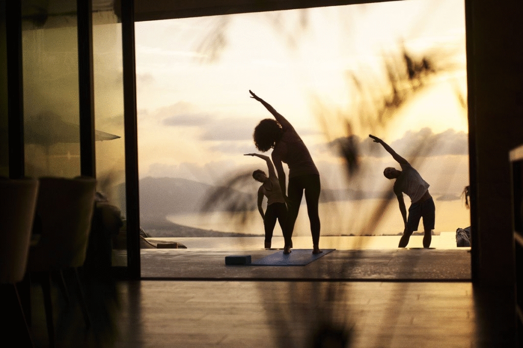 Multigenerational family practicing yoga together on private villa deck at wellness retreat